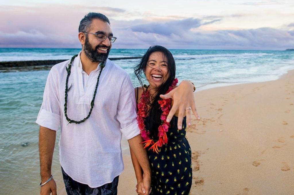 excited engaged couple on the beach in maui
