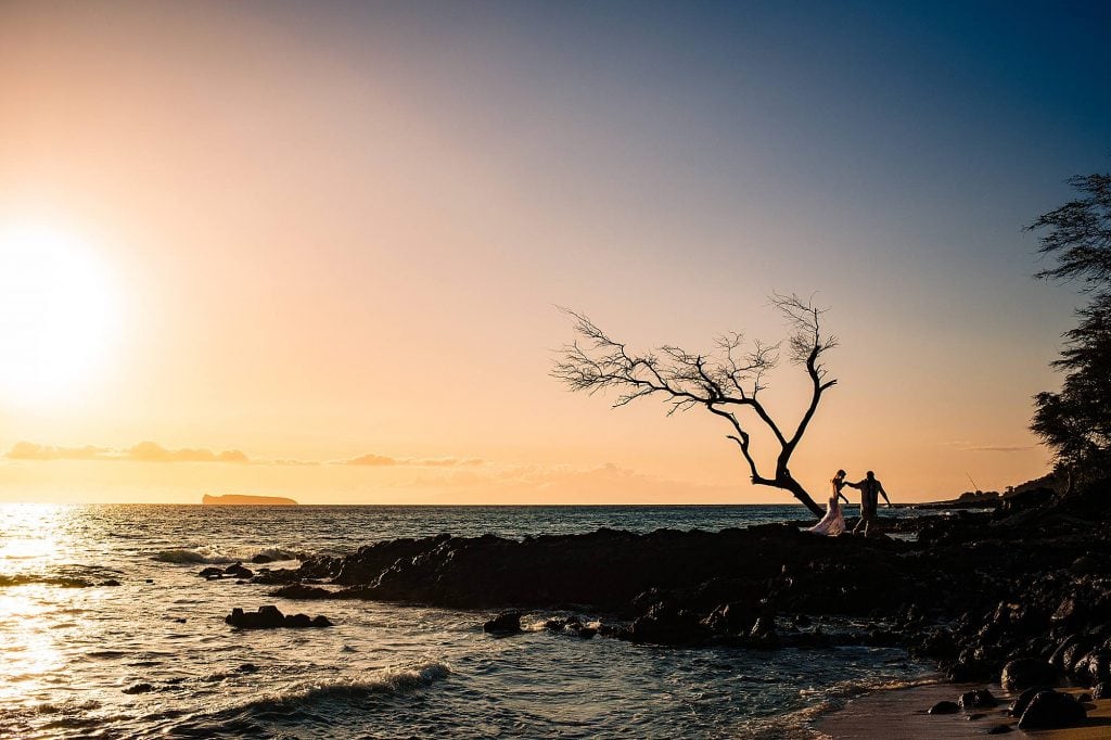 silhouette of bride and groom on lava rocks in hawaii
