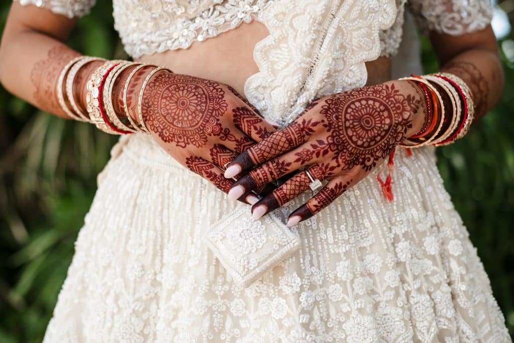 Indian-Wedding-in-Maui-_0006 - Ann Arbor Wedding Photographer A close up photo of the brides hands with their intricate henna designs and her engagement ring displayed.