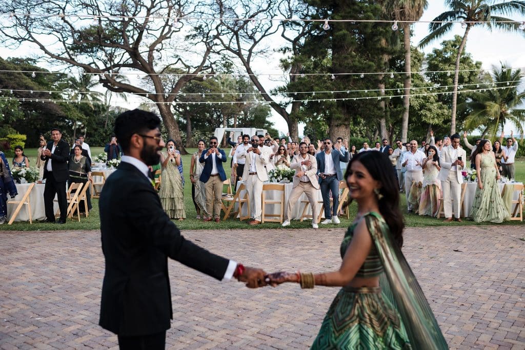 Indian-Wedding-in-Maui-_0033 - Ann Arbor Wedding Photographer All of the wedding guests standing behind the bride and groom and cheering as the man and woman enter the outdoor wedding reception area.
